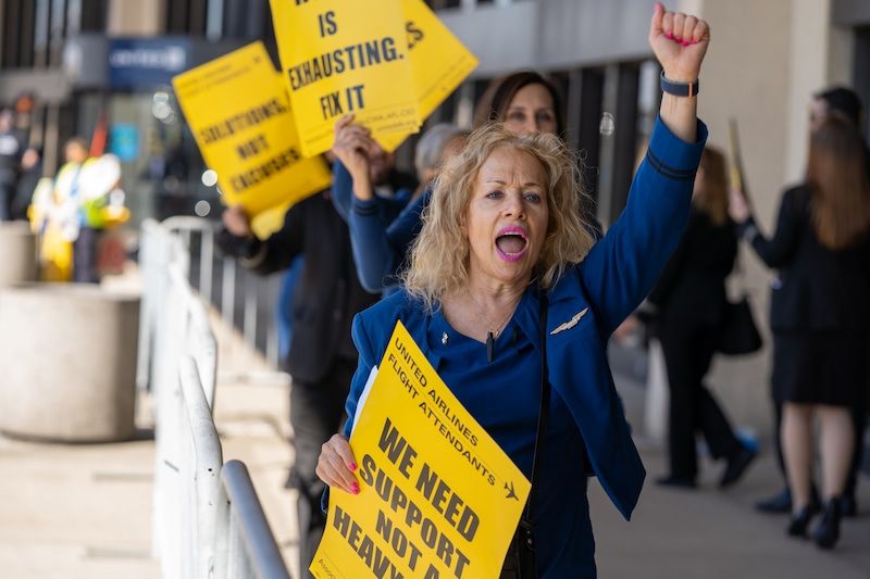 Rita Pearl at an AFA Day of Action protest, raising her fist in solidarity.